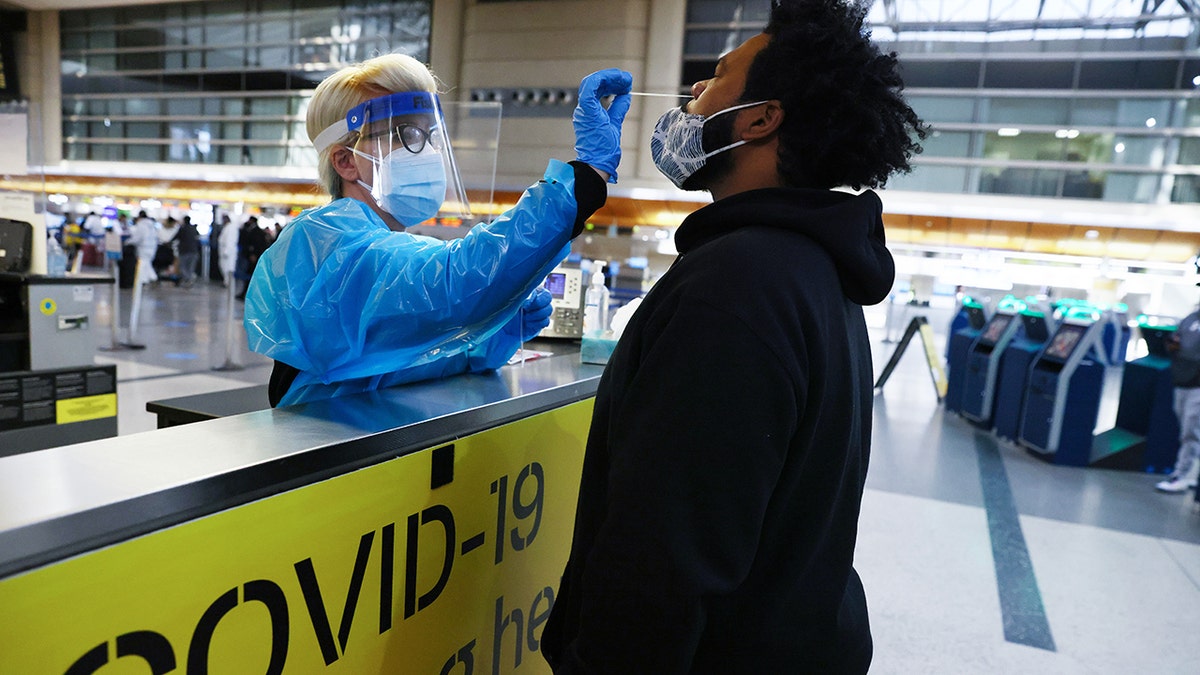 A man receives a nasal swab COVID-19 test at Tom Bradley International Terminal at Los Angeles International Airport (LAX).