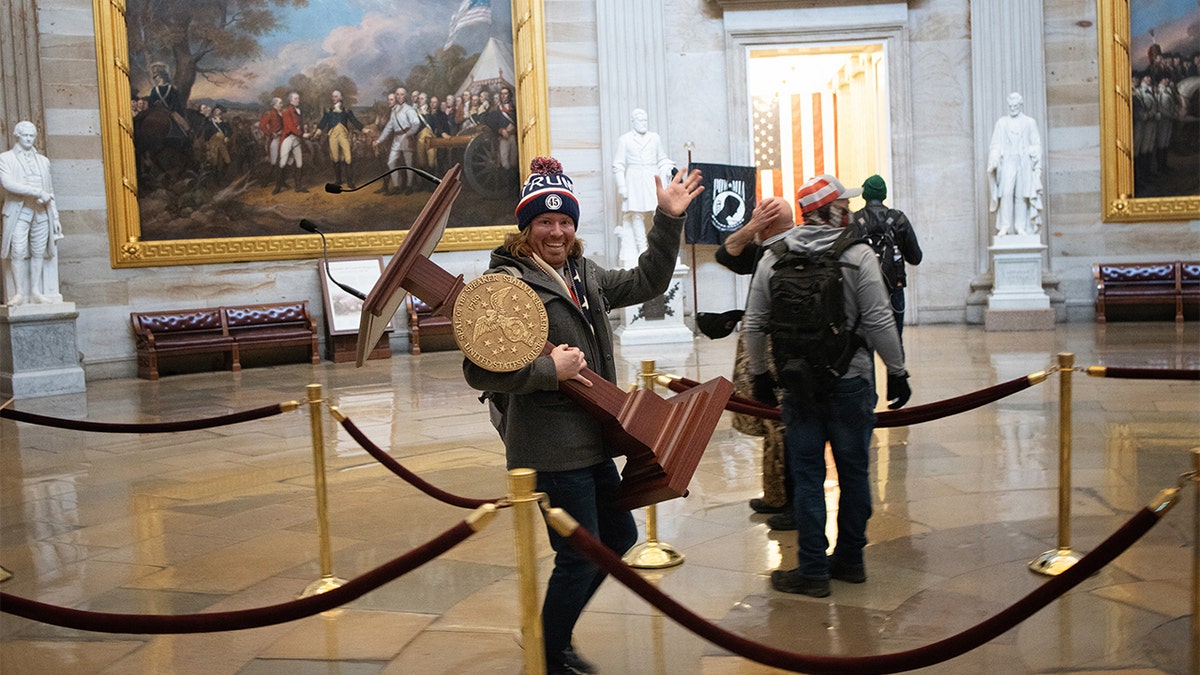 A protester carries the lectern of U.S. House Speaker Nancy Pelosi through the Roturnda of the U.S. Capitol Building, Jan. 6, 2021 in Washington, D.C. (Getty Images)