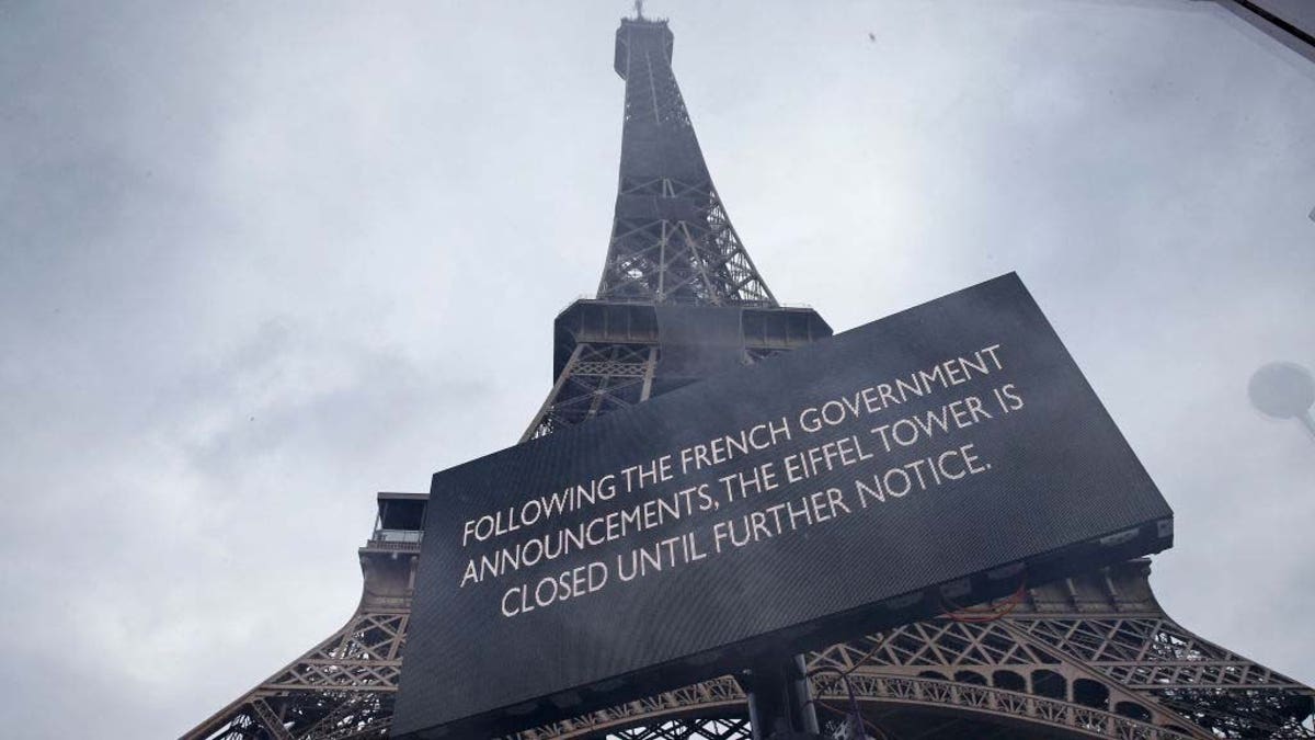 A sign in front of the Eiffel Tower announces its closure to visitors following guidance from the French government.
