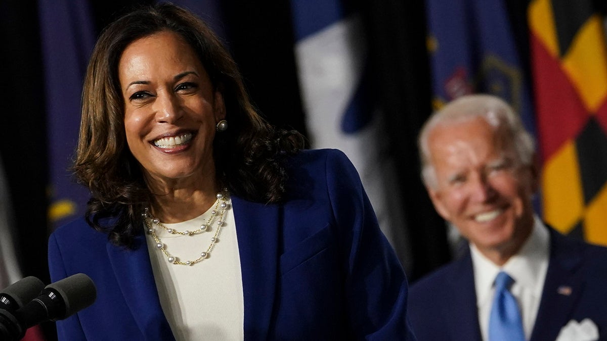 Kamala Harris smiles as Joe Biden looks on