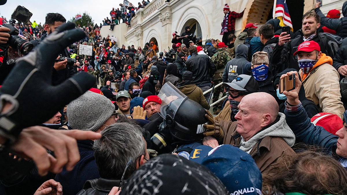 Demonstrators drag and capture a Metropolitan Police officer, while attempting to enter the U.S. Capitol building. (Eric Lee/Bloomberg via Getty Images)