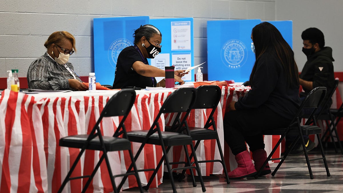 People check in as they prepare to cast their vote in the Georgia runoff election at C.T. Martin Natatorium and Recreation Center on Jan. 5, 2021 in Atlanta. 