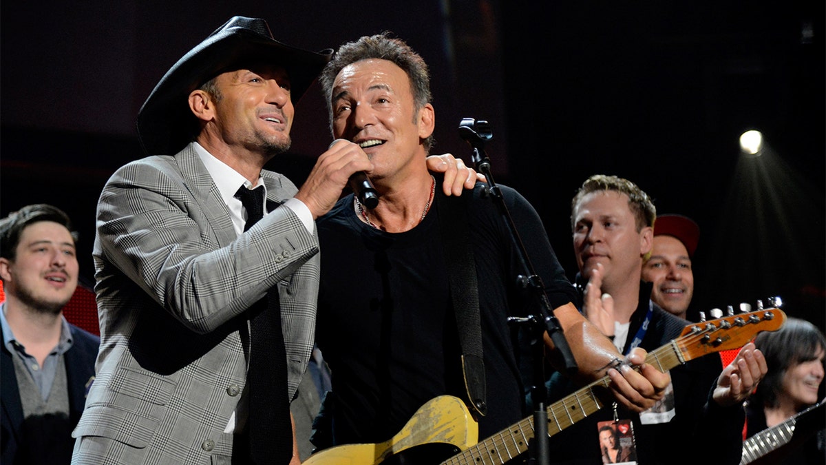 Bruce Springsteen (right) explained how country crooner Tim McGraw (left) cheered him up after losing 'Album of the Year.'