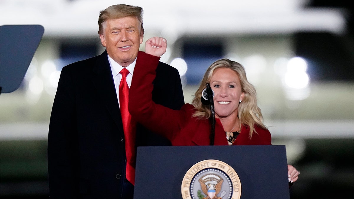 Rep. Marjorie Taylor Greene, R-Ga., speaks as President Donald Trump listens at a campaign rally in support of Senate candidates Sen. Kelly Loeffler, R-Ga., and David Perdue in Dalton, Ga., Monday, Jan. 4, 2021. (AP Photo/Brynn Anderson)