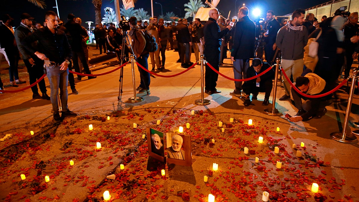 Popular Mobilization Forces and their supporters light candles at Baghdad's international airport on Saturday, Jan. 2, 2021, on the anniversary of the killing of Abu Mahdi al-Muhandis, deputy commander of the PMF and Gen. Qassem Soleimani, head of Iran's Quds forces. (Associated Press)