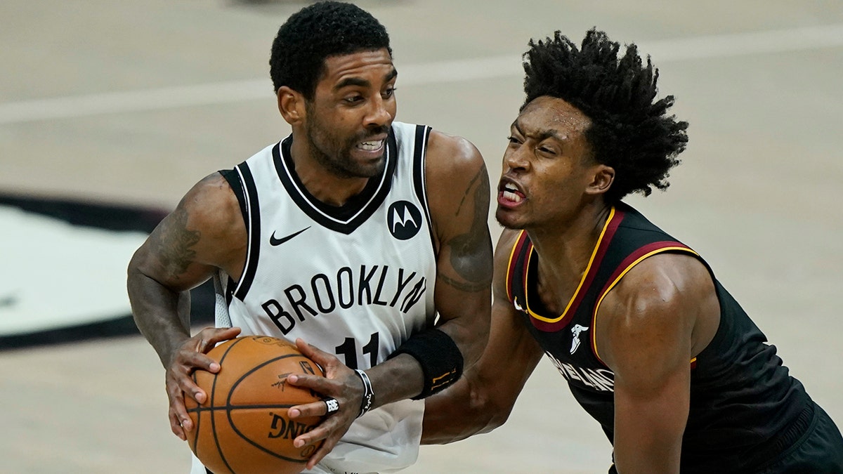 Brooklyn Nets' Kyrie Irving, left, drives past Cleveland Cavaliers' Collin Sexton in the second half of an NBA basketball game, Friday, Jan. 22, 2021, in Cleveland. The Cavaliers won 125-113. (AP Photo/Tony Dejak)