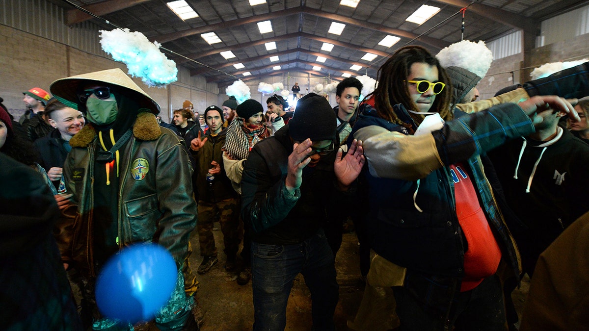 People dance during a party near a disused hangar in Lieuron about 40km (around 24 miles) on south of Rennes, on January 1, 2021. - A wild party that began on December 31 evening in Lieuron, still gathered on January 1 around 2,500 participants " from different departments and from abroad ", according with a press release from the prefecture of Ille-et-Vilaine. (Photo by JEAN-FRANCOIS MONIER / AFP) (Photo by JEAN-FRANCOIS MONIER/AFP via Getty Images)