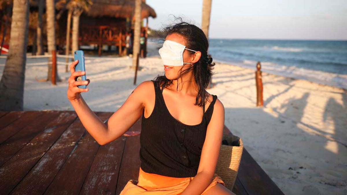 Mexico City resident Romina Montoya takes a playful selfie wearing a protective face mask over her eyes and nose. (AP Photo/Emilio Espejel)