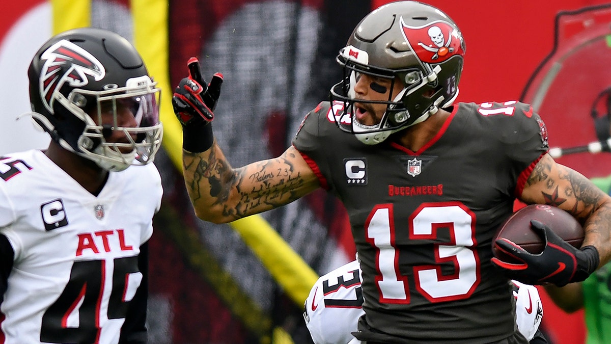 Tampa Bay Buccaneers wide receiver Mike Evans (13) reacts after catching a pass in front of Atlanta Falcons linebacker Deion Jones (45) during the first half of an NFL football game Sunday, Jan. 3, 2021, in Tampa, Fla. Evans' reception put him over the 1,000-yard mark for the season. (AP Photo/Jason Behnken)