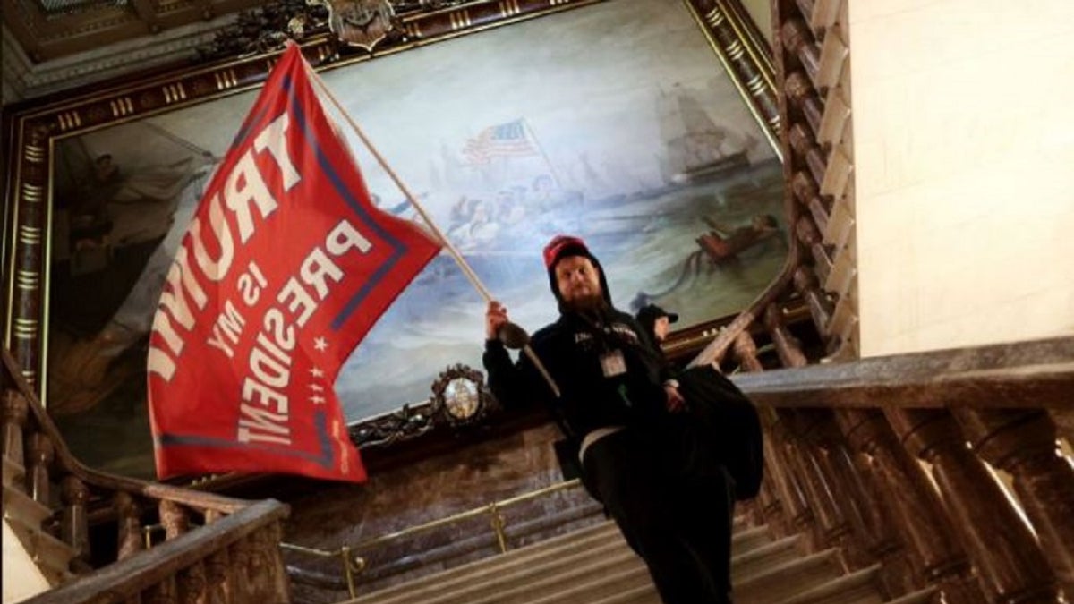 Nicholas Rodean is seen carrying a large pro-Trump flag inside the U.S. Capitol, authorities said. Rodean and six others were charged in connection with the Jan. 6 riot inside the building, the Justice Department said Wednesday.