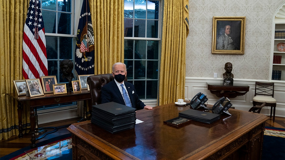 President Joe Biden signs a series of executive orders in the Oval Office of the White House, Wednesday, Jan. 20, 2021, in Washington. (AP Photo/Evan Vucci)