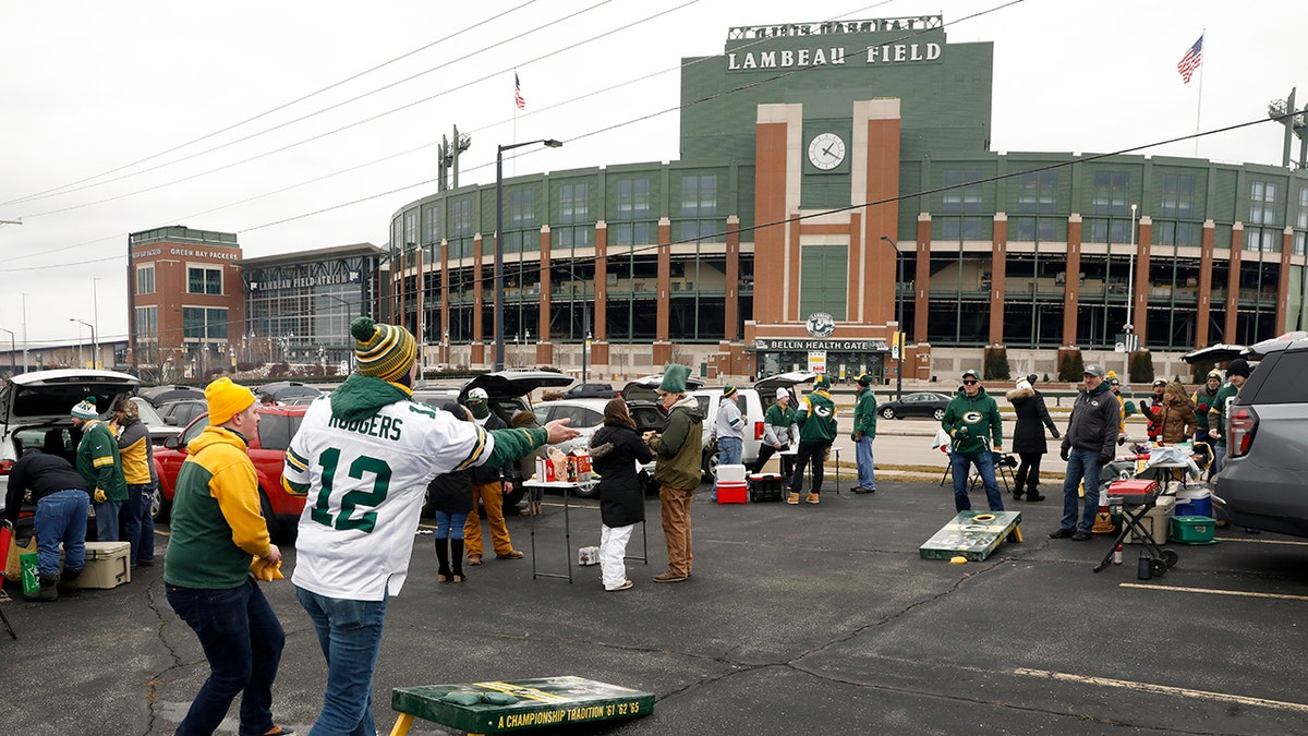 Fans toss bean bags outside of Lambeau Field before an NFL divisional playoff football game between the Los Angeles Rams and Green Bay Packers, Saturday, Jan. 16, 2021, in Green Bay, Wis. (AP Photo/Mike Roemer)