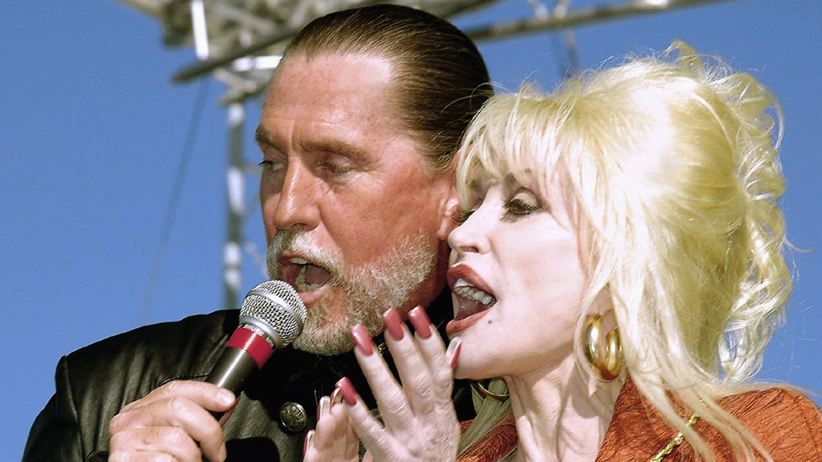 Dolly Parton shares the microphone with brother Randy Parton in Roanoke Rapids, N.C. in 2005. 