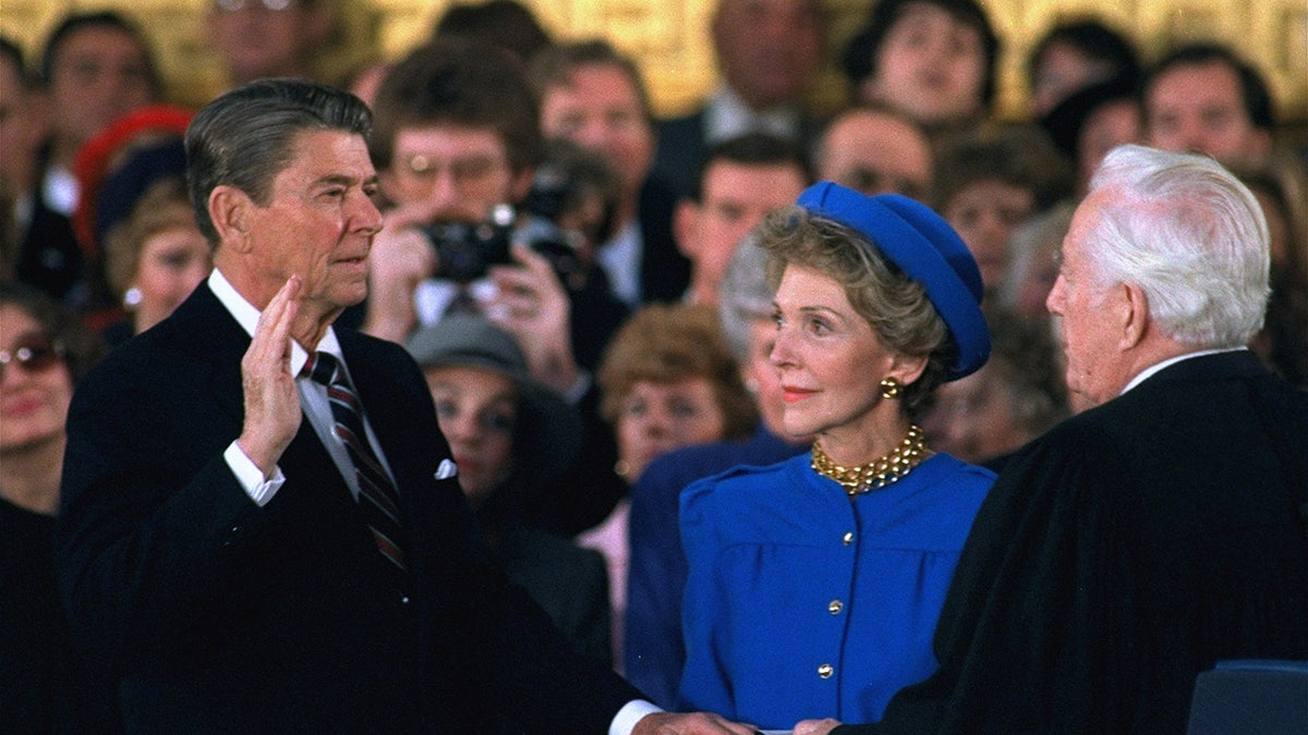 First Lady Nancy Reagan looks on as President Ronald Reagan is sworn in
