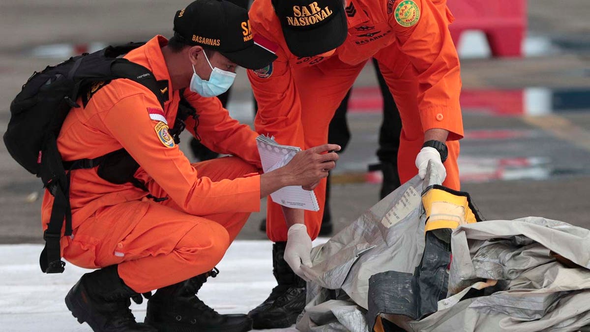 Rescuers inspect debris found in the waters around the location where a Sriwijaya Air passenger jet has lost contact with air traffic controllers shortly after the takeoff, at the search and rescue command center at Tanjung Priok Port in Jakarta, Indonesia, Sunday, Jan. 10, 2021. (Asssociated Press)