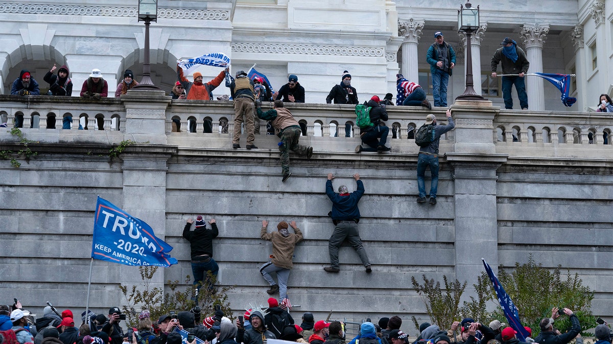 Protesters climb the west wall of the U.S. Capitol on Wednesday, Jan. 6, 2021, in Washington, D.C.