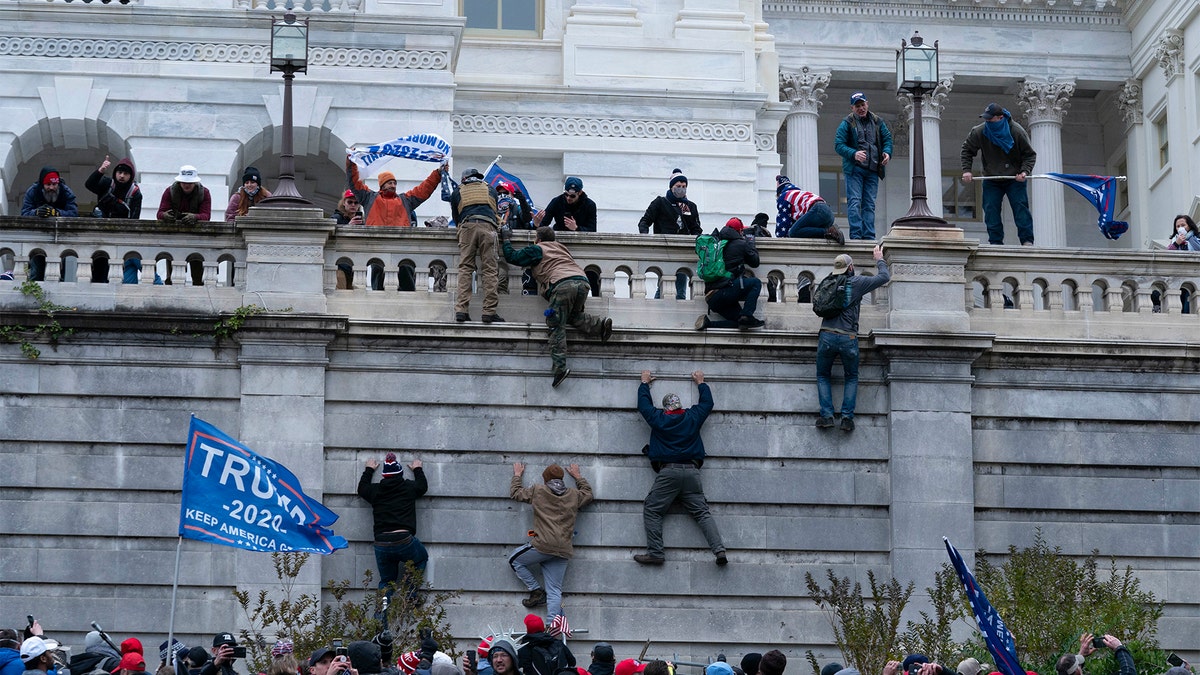 Protesters climb the west wall of the U.S. Capitol on Wednesday, Jan. 6, 2021, in Washington, D.C.