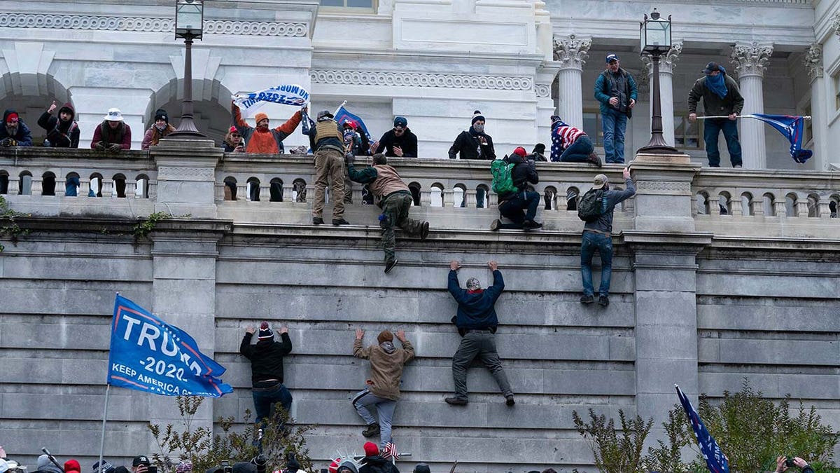 Supporters of President Donald Trump climb the west wall of the the U.S. Capitol on Wednesday, Jan. 6, 2021, in Washington.