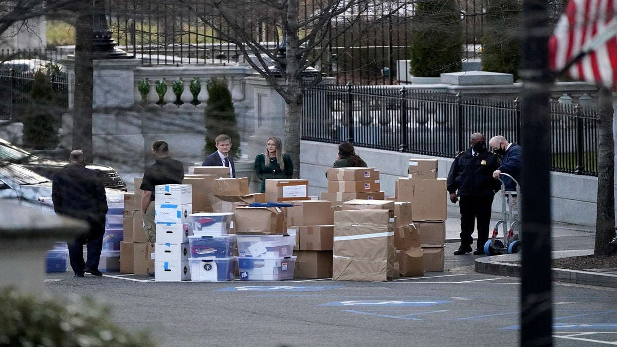 People wait for a moving van after boxes were moved out of the Eisenhower Executive Office building inside the White House complex on Thursday. (AP)