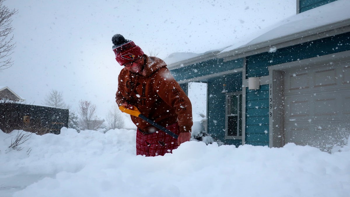 Tim Ahlman shovels snow outside his home in Bellemont, Ariz. on Monday. (AP)