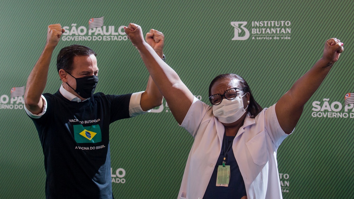 Nurse Monica Calazans, 54, and the Governor of Sao Paulo Joao Doria celebrate after she got her shot of the COVID-19 vaccine produced by China’s Sinovac Biotech Ltd, at the Hospital das Clinicas in Sao Paulo, Brazil, Sunday, Jan. 17, 2021. 