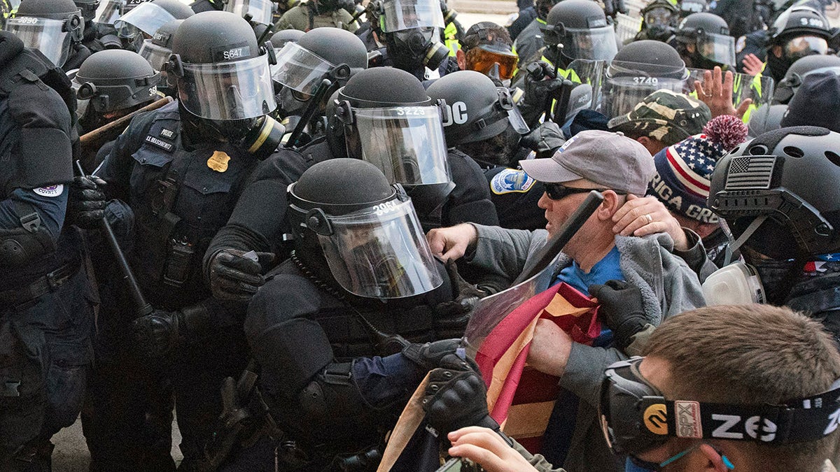 Capitol police officers in riot gear push back demonstrators who try to break a door of the U.S. Capitol on Wednesday, Jan. 6, 2021, in Washington. (AP Photo/Jose Luis Magana)