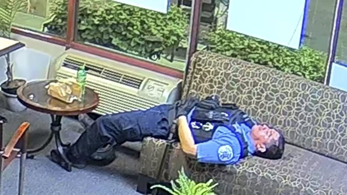 In this file still image taken from security video released by the Congressman Bobby Rush's Campaign Office, a Chicago police officer lies on a couch inside Rush's burglarized congressional campaign office in Chicago on Sunday, May 31, 2020. Chicago Police suspended several officers captured on video during 2020's widespread unrest who were lounging, and apparently even sleeping, inside a burglarized congressional campaign office as people citywide vandalized and stole from businesses, a police union official said, Thursday, Jan. 14, 2021