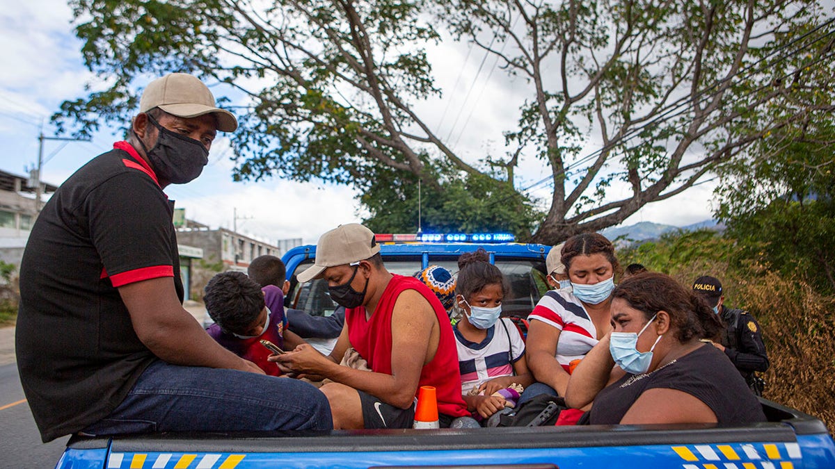Honduran migrants sit in the bed of a police vehicle after they were detained in Chiquimula, Guatemala, Tuesday, Jan. 19, 2021. (AP Photo/Oliver de Ros)