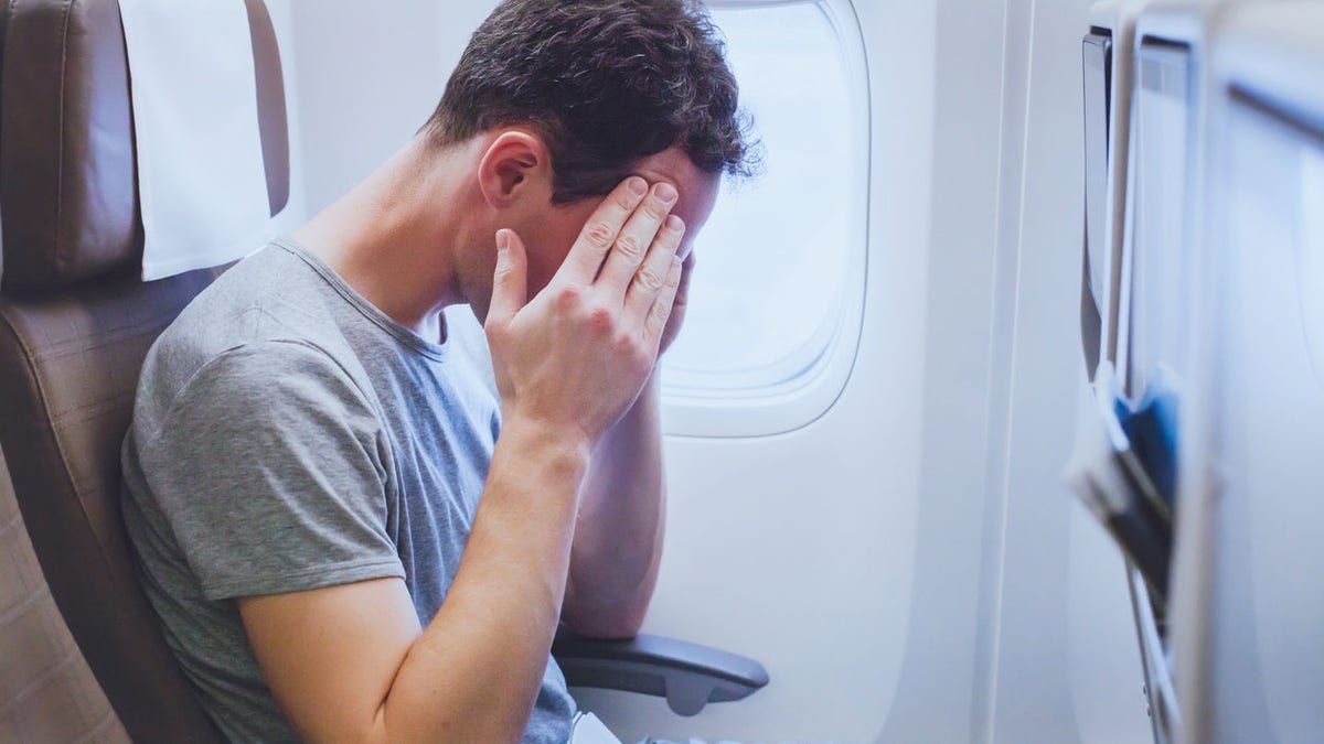 headache in the airplane, man passenger afraid and feeling bad during flight, fear