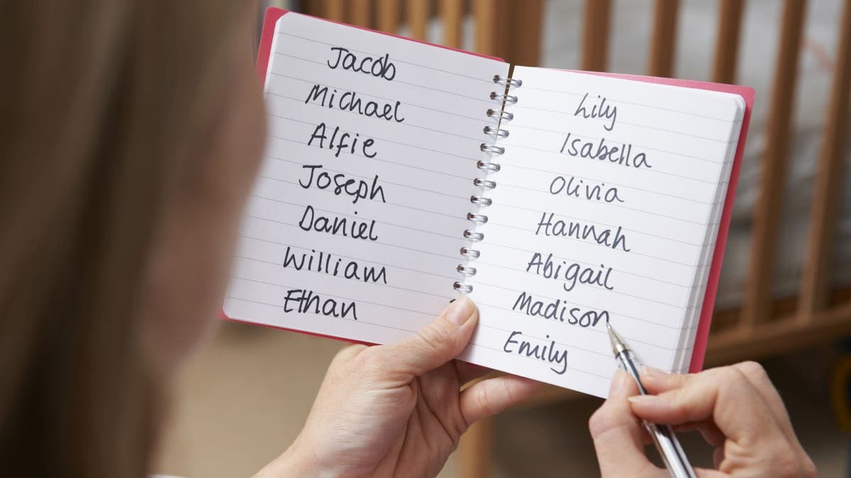Woman looks at baby names in book