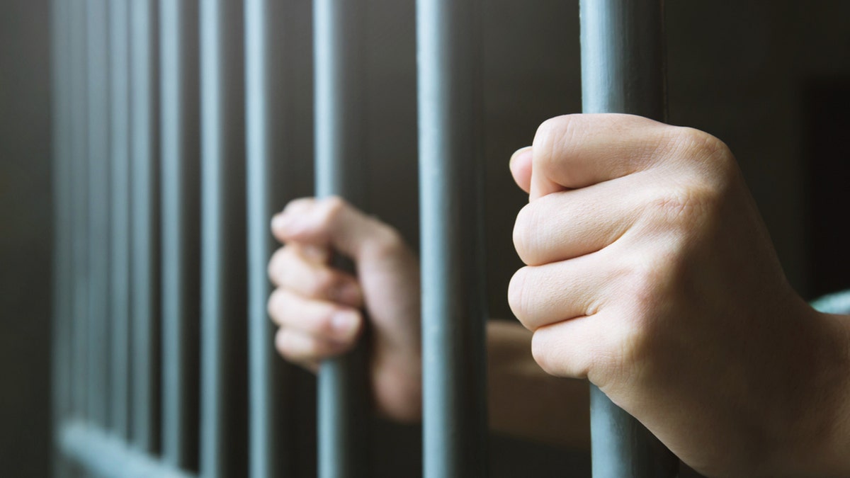 Man holding prison bars