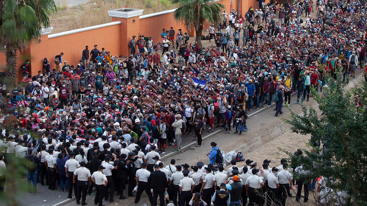 Honduran migrants gather in front of a police roadblock at a highway in Vado Hondo, Guatemala, Guatemala, Sunday, Jan. 17, 2021.  (AP Photo/Sandra Sebastian)