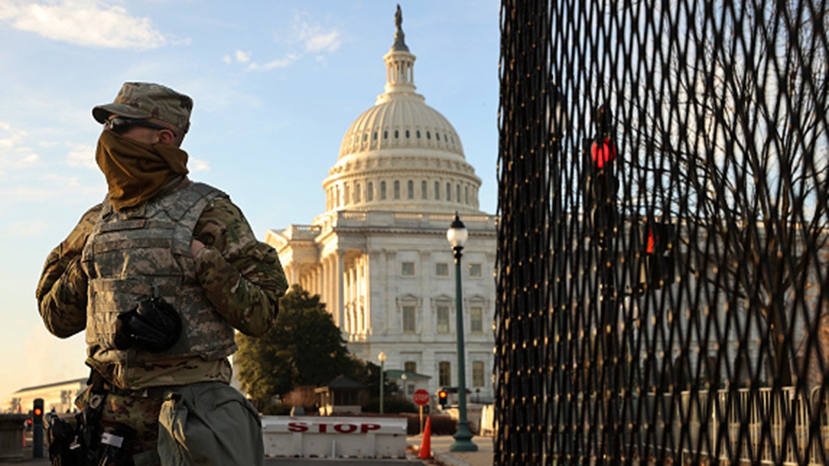 A member of the New York National Guard stands at a gate outside the U.S. Capitol the day after the House of Representatives voted to impeach President Trump for the second time Jan. 14, 2021 in Washington, D.C. 