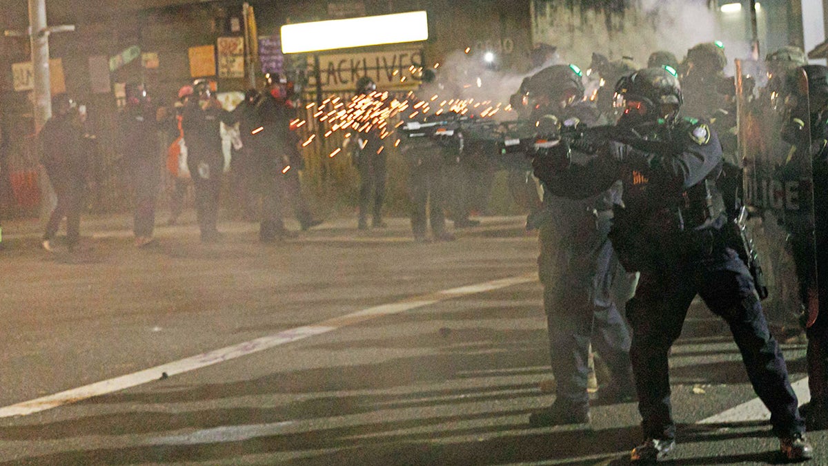 Police fire tear gas at demonstrators during a protest against ICE in Portland, Oregon