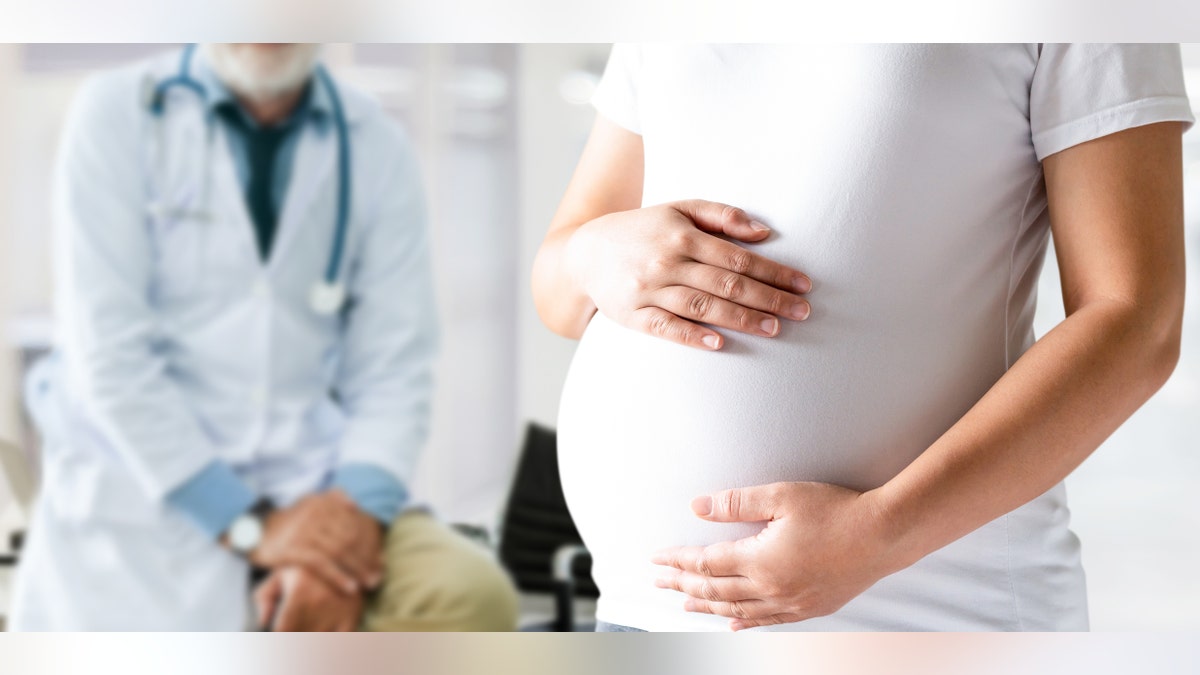 pregnant woman touches belly