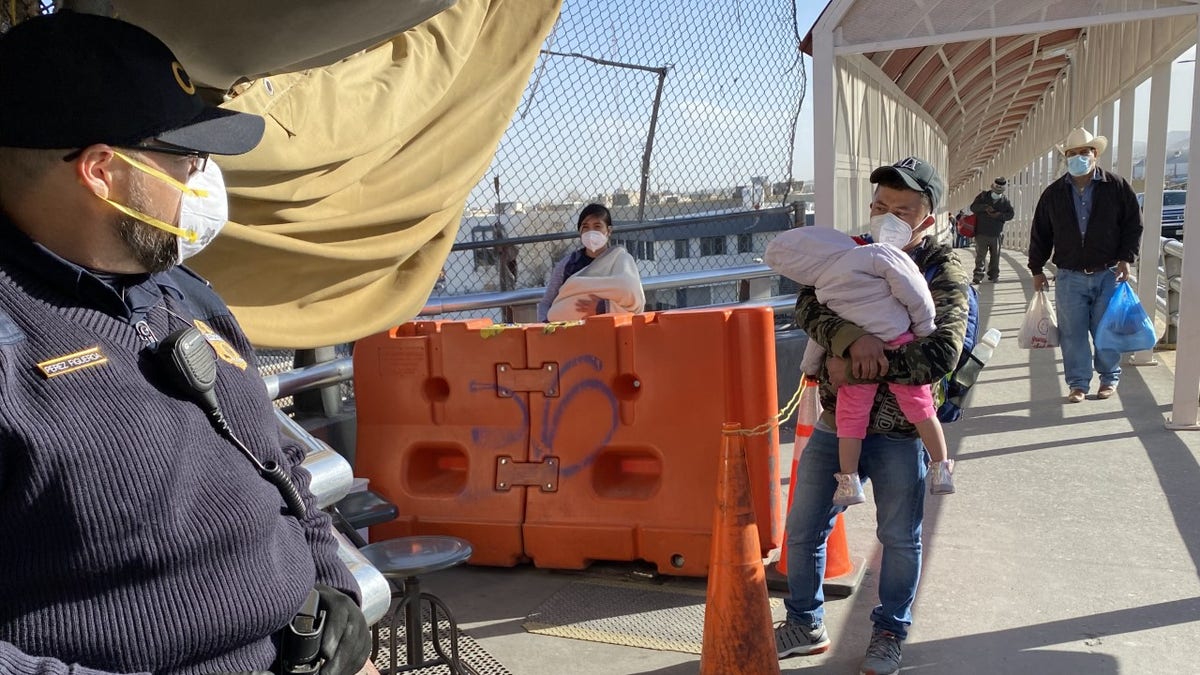 A man holds his child at a border stop in Juarez, Mexico.