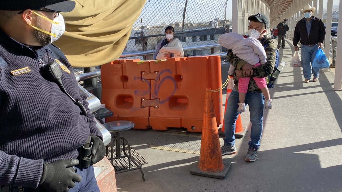 A man holds his child at a border stop in Juarez, Mexico.
