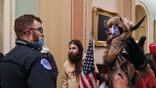 US Capitol police officers try to stop supporters of US President Donald Trump, including Jake Angeli (R), a QAnon supporter known for his painted face and horned hat, to enter the Capitol on January 6, 2021, in Washington, DC. - Demonstrators breeched security and entered the Capitol as Congress debated the a 2020 presidential election Electoral Vote Certification. (Photo by Saul LOEB / AFP) (Photo by SAUL LOEB/AFP via Getty Images)