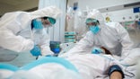 Two doctors work on a patient.