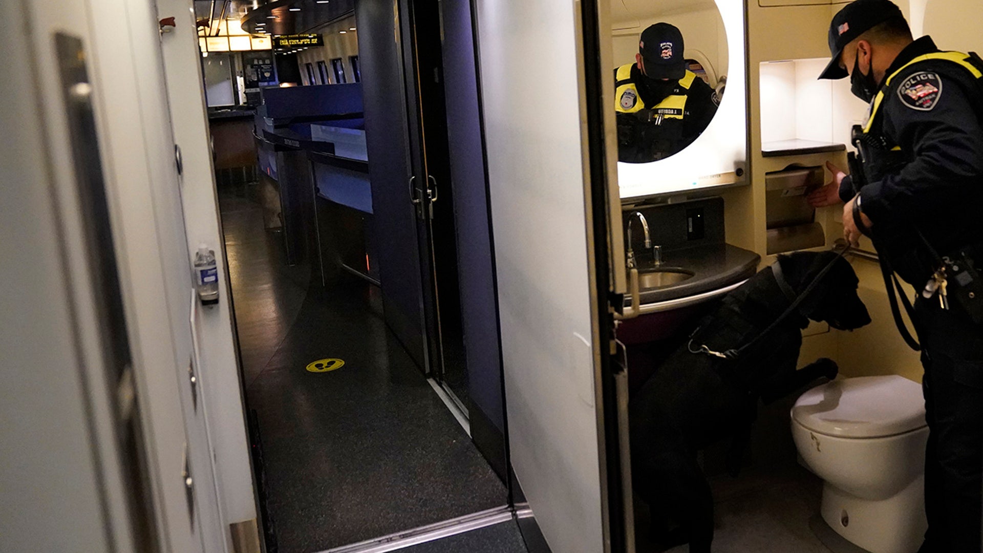 An Amtrak K9 officer and his dog check the lavatory in an Amtrak train before its departure from Union Station as security is heightened ahead of President-elect Joe Biden's inauguration ceremony, Tuesday, Jan. 19, 2021, in Washington.