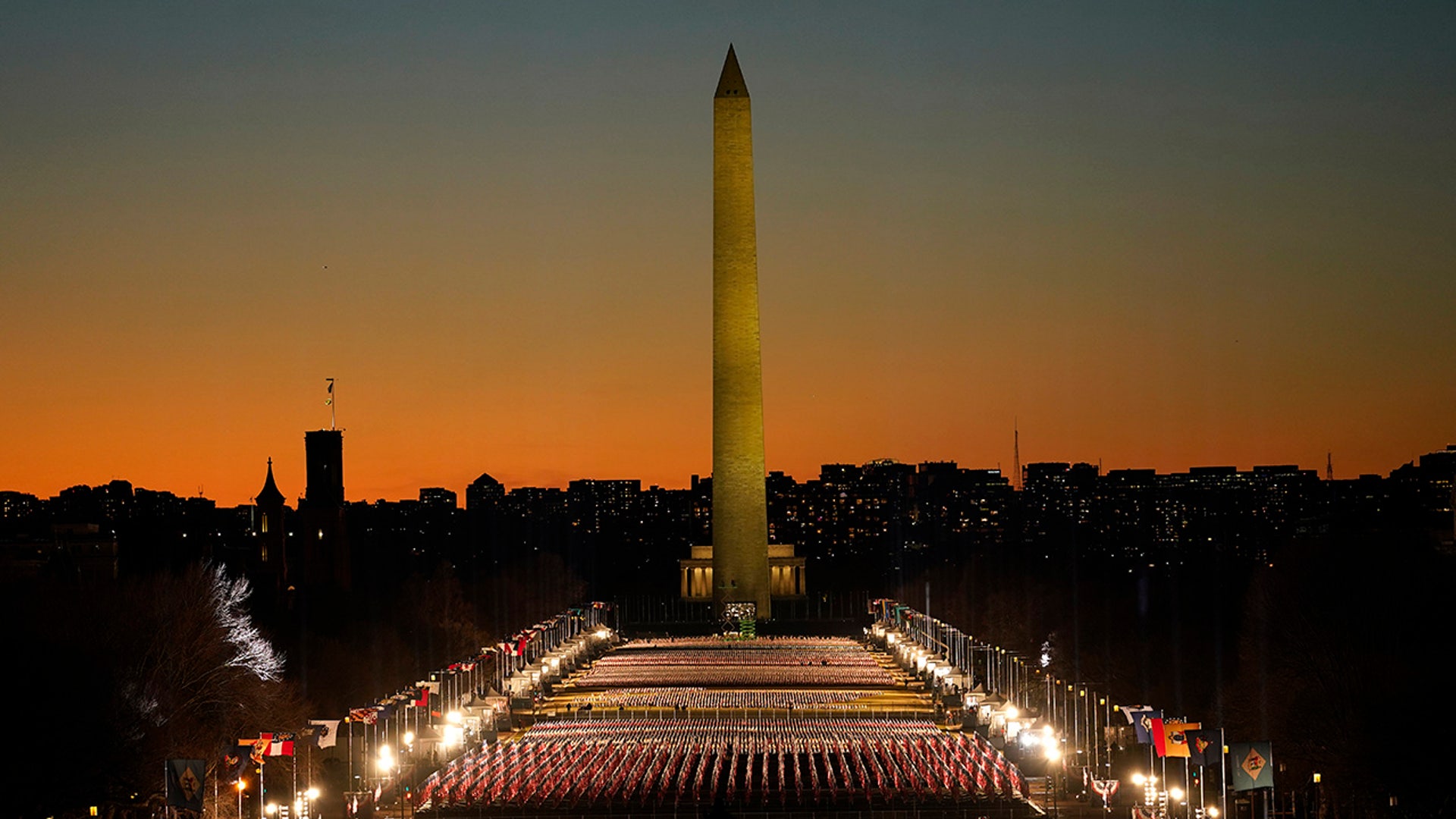 A field of flags is spread across the National Mall, with the Washington Monument in the background on Tuesday, Jan. 19, 2021, as seen from the West Front of the U.S. Capitol on the evening ahead of the 59th presidential inauguration in Washington.