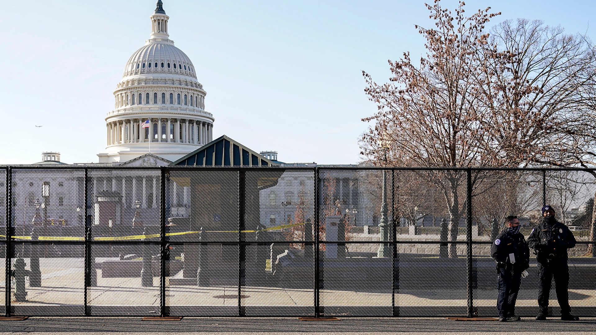 Capitol police officers stand outside of fencing that was installed around the exterior of the Capitol grounds, Thursday, Jan. 7, 2021 in Washington. The House and Senate certified the Democrat's electoral college win early Thursday after a violent throng of pro-Trump rioters spent hours Wednesday running rampant through the Capitol. A woman was fatally shot, windows were bashed and the mob forced shaken lawmakers and aides to flee the building, shielded by Capitol Police. (AP Photo/John Minchillo)