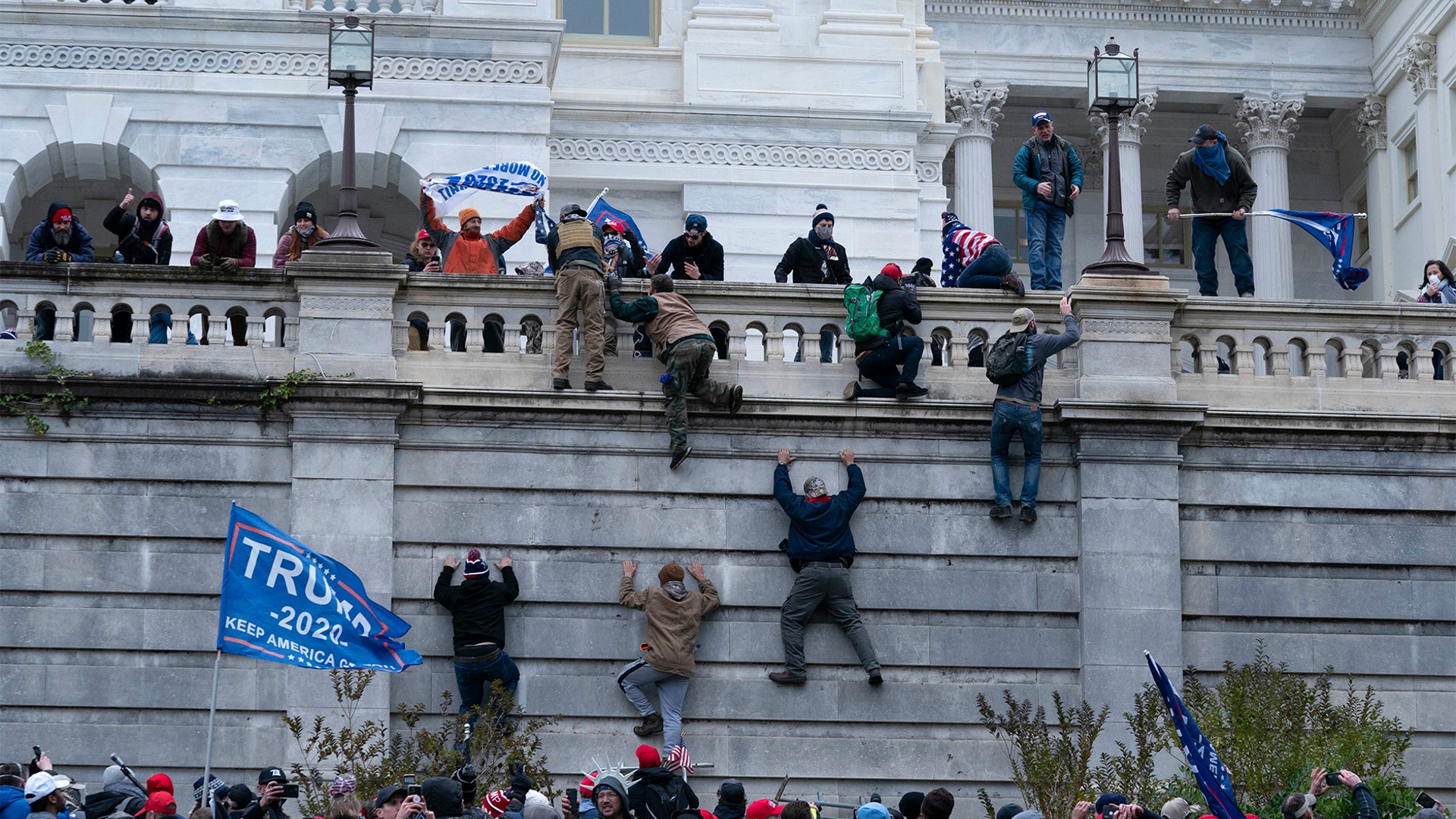 Supporters of President Trump climb the west wall of the the U.S. Capitol on Wednesday, Jan. 6, 2021, in Washington.