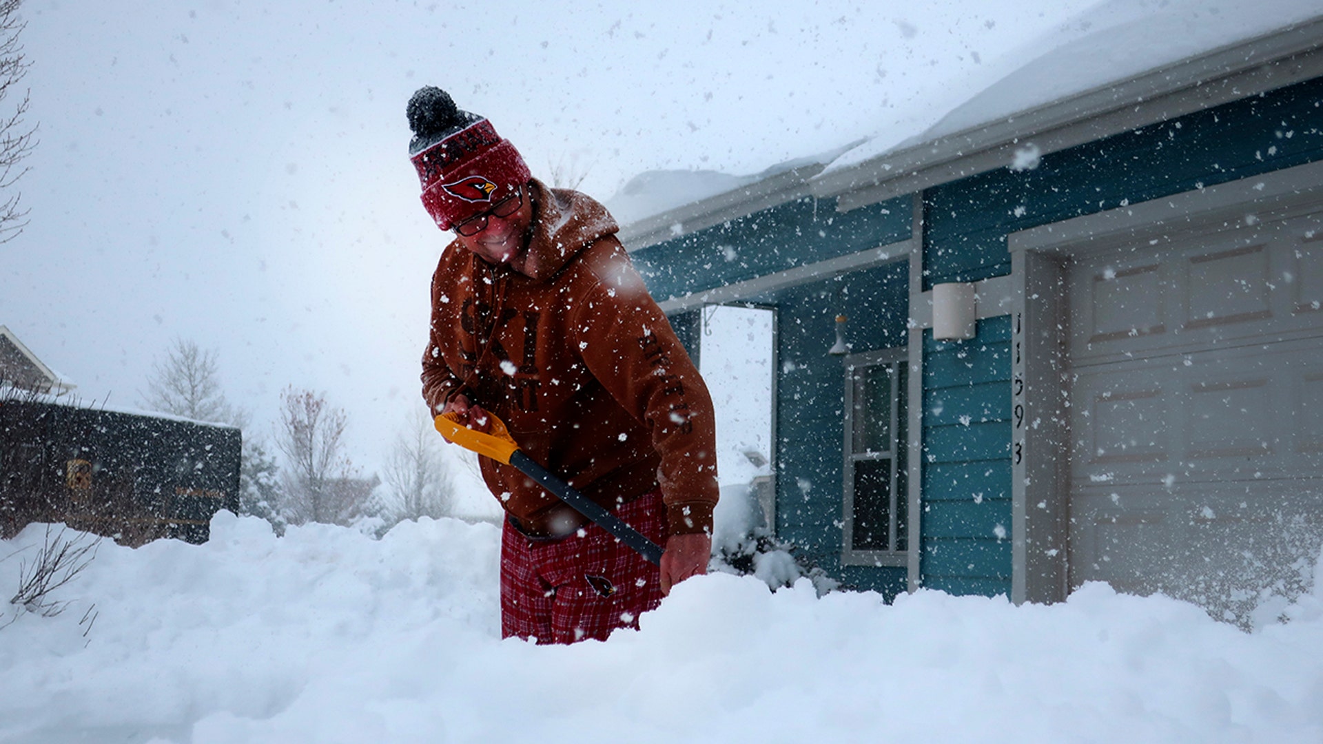 Tim Ahlman shovels snow outside his home in Bellemont, Ariz., Monday, Jan. 25, 2021. A series of winter storms has dropped more precipitation in Flagstaff than the city had during last summer's monsoon season. The recent snow measured as water topped the amount of rain that fell from mid-June through September, the driest monsoon season on record.