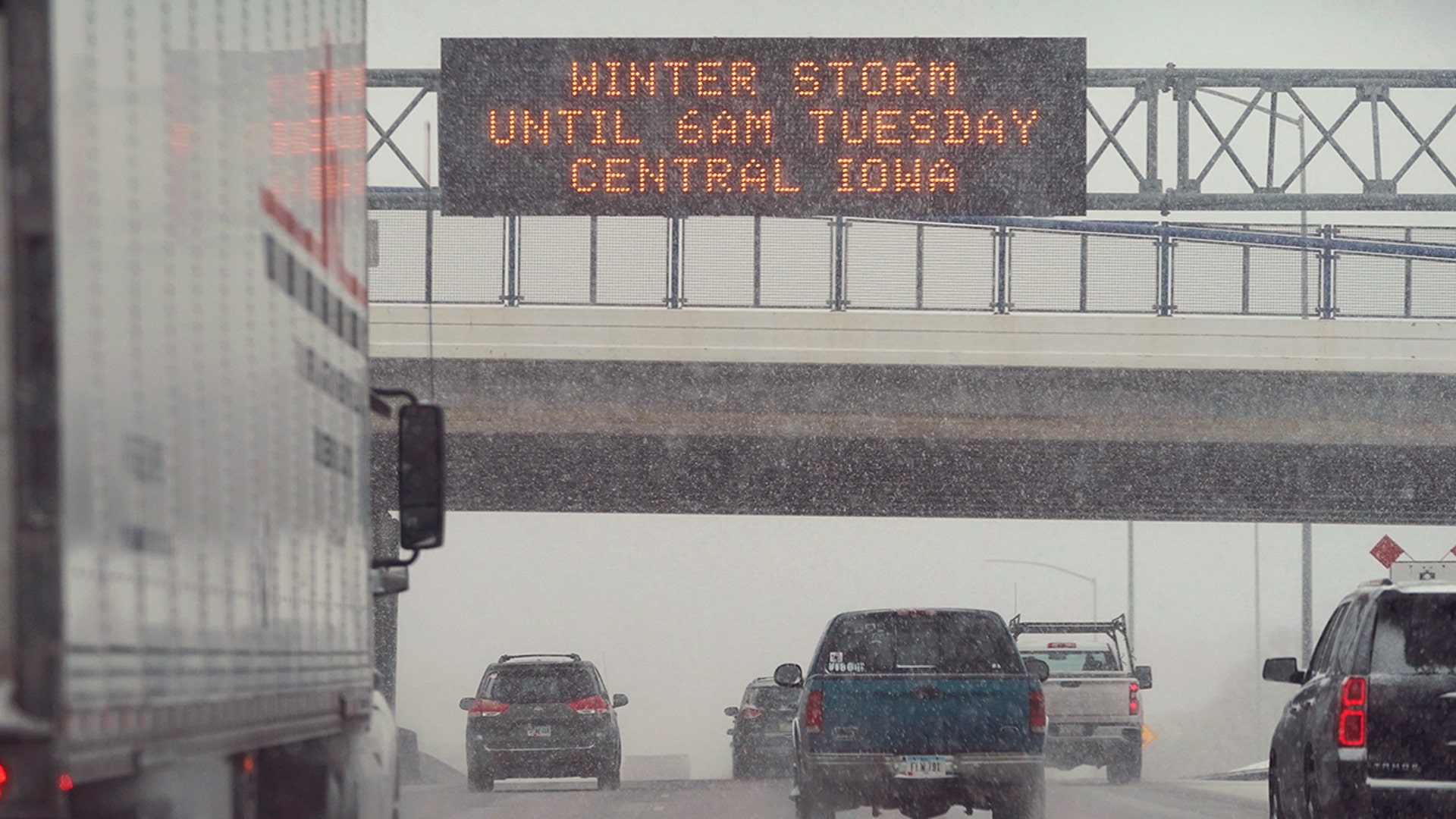Traffic passes a sign warning of a winter storm, Monday, Jan. 25, 2021, in Des Moines, Iowa. A major winter storm is expected to blanket a large swath of the middle of the country with snow Monday and disrupt travel as more than a foot of snow falls in some areas.