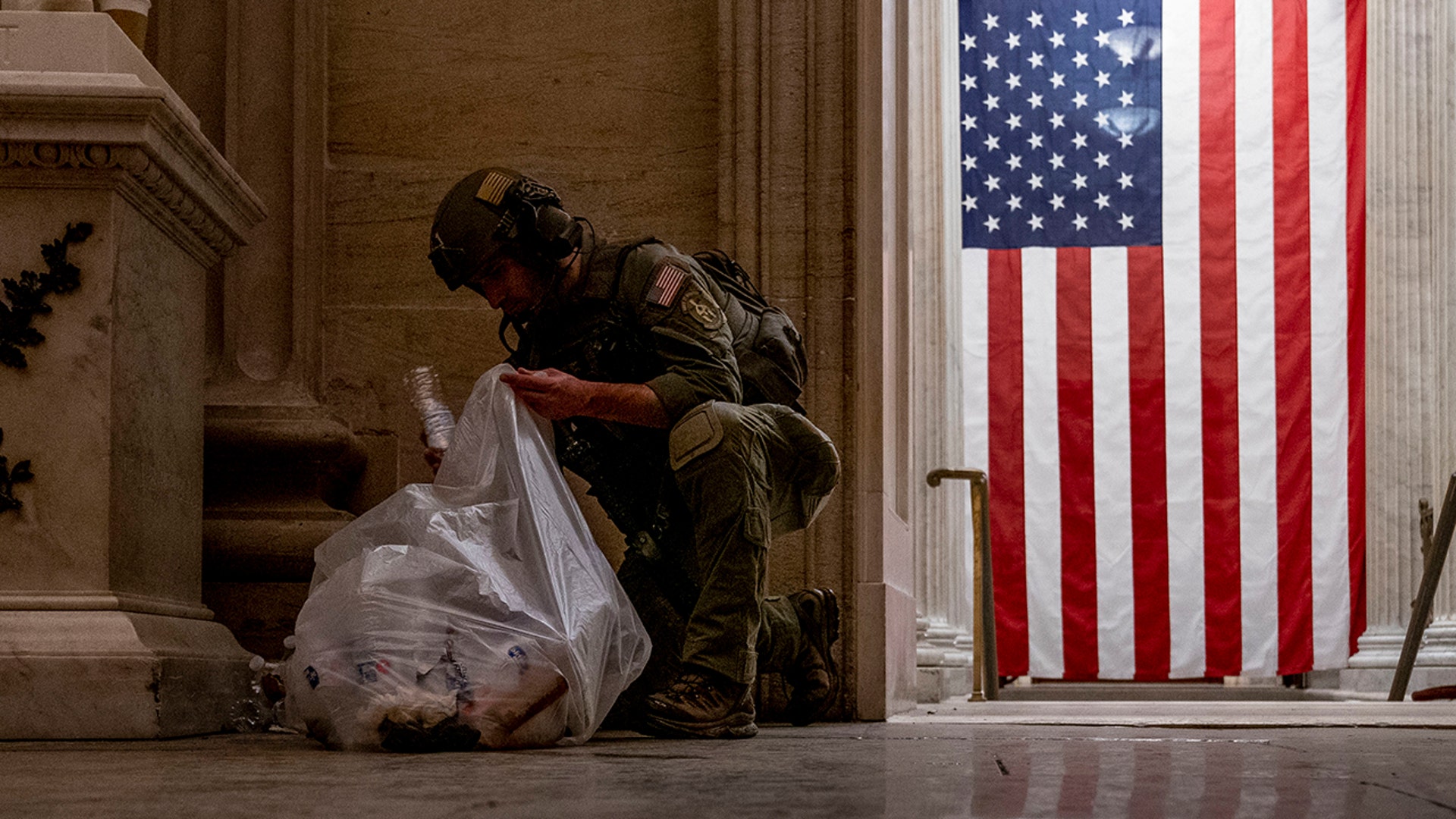 An ATF police officer cleans up debris and personal belongings strewn across the floor of the Rotunda in the early morning hours of Thursday, Jan. 7, 2021, after protesters stormed the Capitol in Washington, on Wednesday.