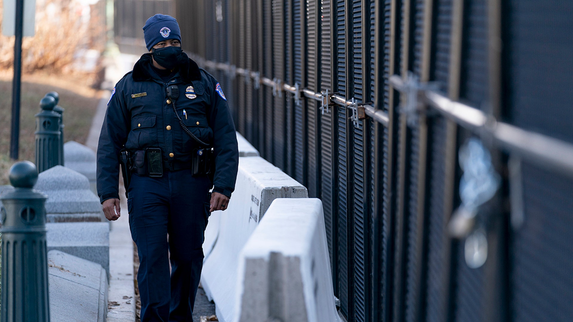 A U.S. Capitol Police officer walks along fencing installed along the perimeter of the Capitol building on Capitol Hill in Washington, Thursday, Jan. 14, 2021