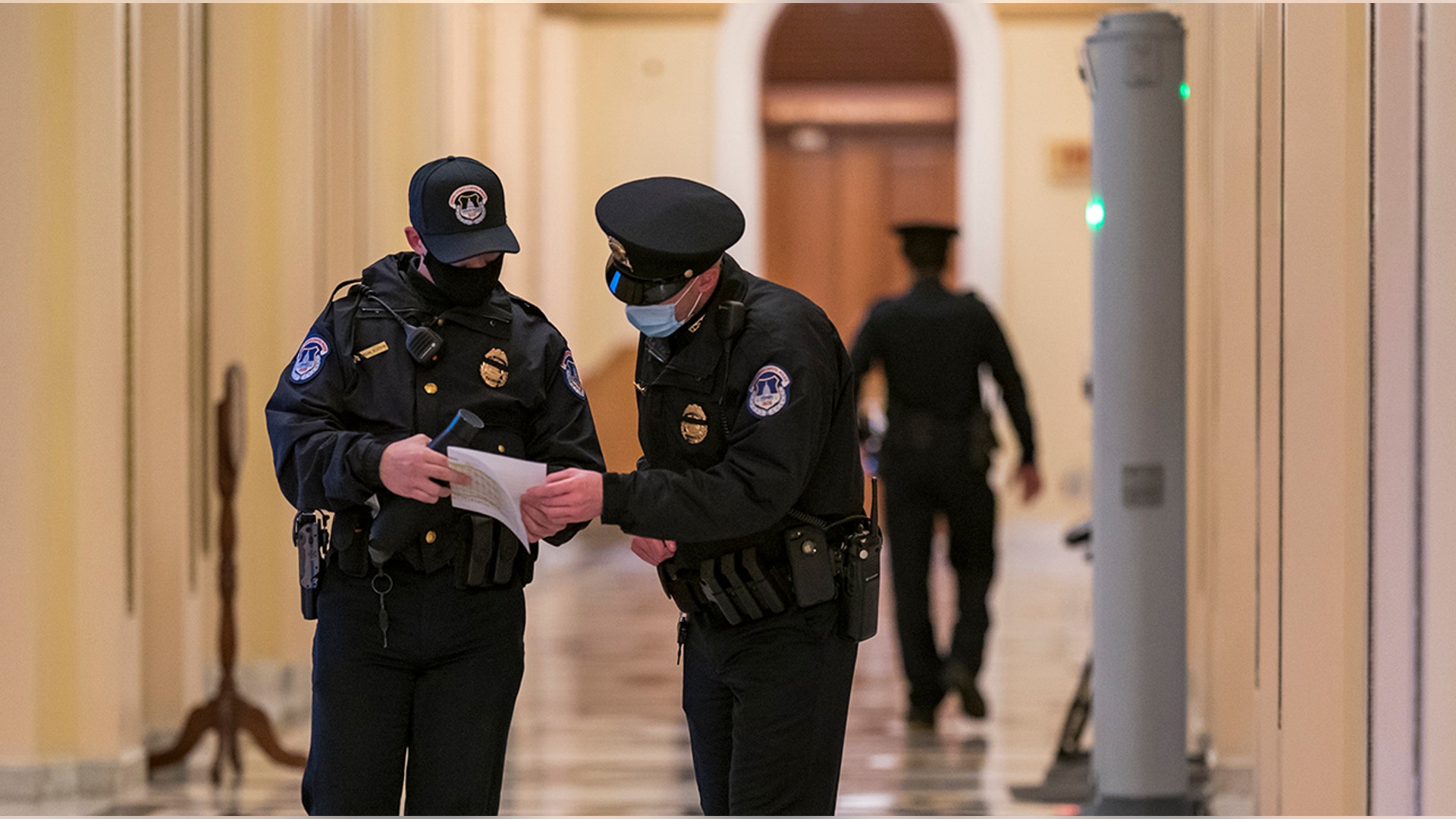 U.S. Capitol Police survey the corridor around the House of Representatives chamber after enhanced security protocols were enacted, including metal detectors for lawmakers, after a mob loyal to President Donald Trump stormed the Capitol, in Washington, Tuesday, Jan. 12, 2021.