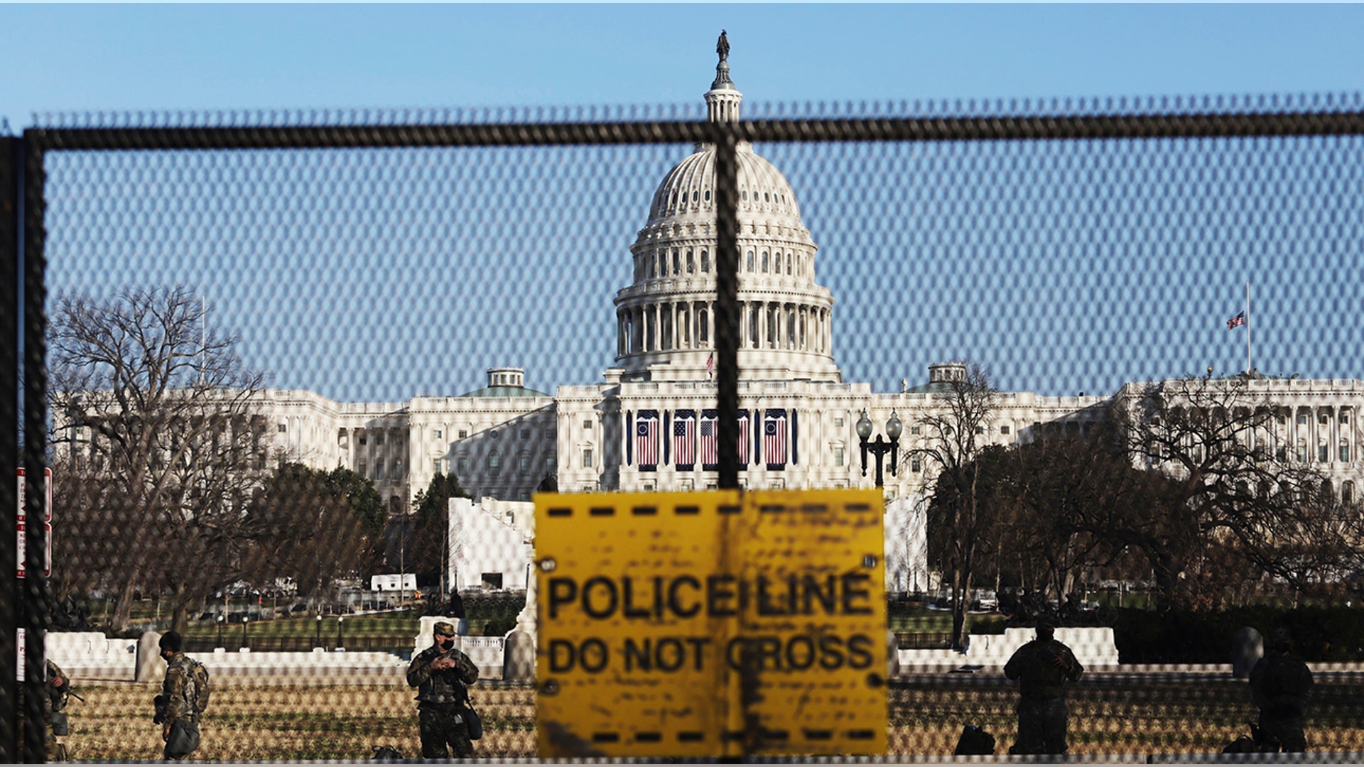 National guards are seen Wednesday, Jan. 13, 2021 on a fence that was erected to reinforce security at the Capitol in Washington. (AP Photo/Shafkat Anowar)