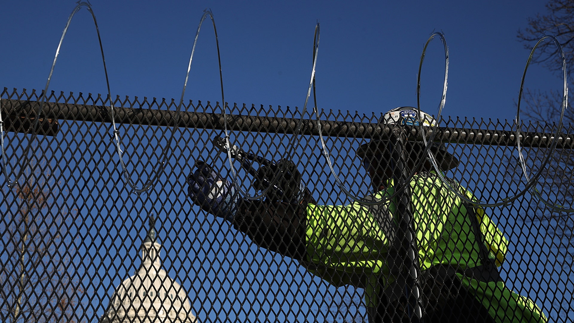 Workers put concertina razor wire along the top of the 8-foot "non-scalable" fence that surrounds the U.S. Capitol the day after the House of Representatives voted to impeach President Donald Trump for the second time Jan. 14, 2021, in Washington, D.C. Thousands of National Guardsmen have been activated to protect the nation's capital against threats surrounding President-elect Joe Bidenโs inauguration and to prevent a repeat of last weekโs deadly insurrection at the U.S. Capitol. (Photo by Chip Somodevilla/Getty Images)